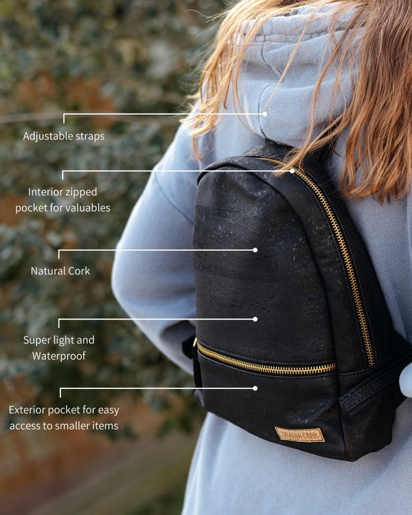 Person wearing a black backpack with features highlighted, outdoors.