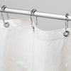 White shower curtain with silver rings on a gray background