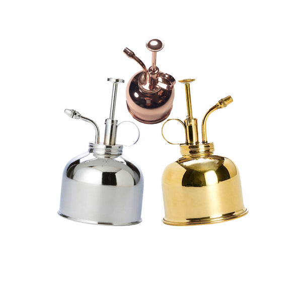 Three metallic oil lamps in silver, gold, and rose gold on a white background.