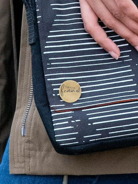 Close-up of brass feminist pin, nickel-free and ethically made, measuring 1 inch – Fair Anita