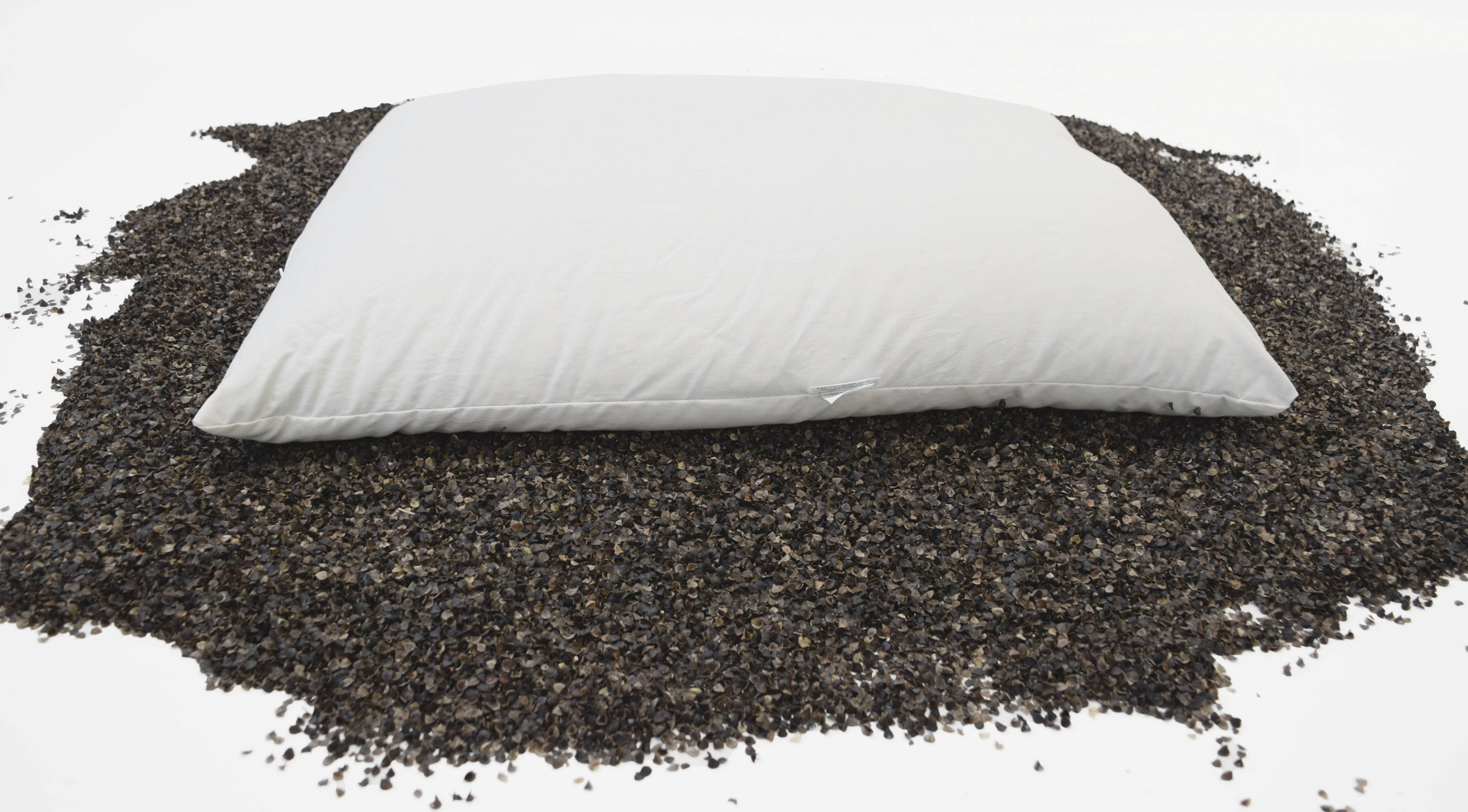 White pillow on a bed of black seeds or grains