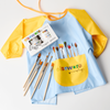 Yellow and blue apron with paintbrushes and finger paint set on a white background