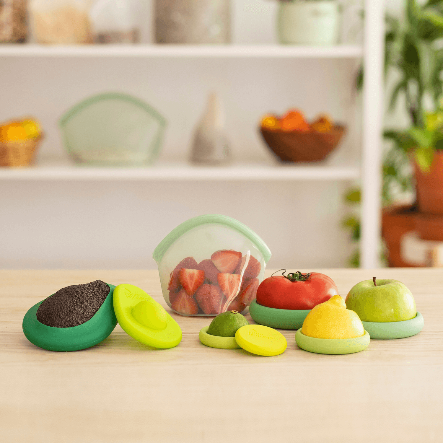 Colorful silicone food covers on a kitchen counter with a fruit container in the background.