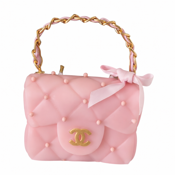 Pink handbag with gold handle and bow on a white background