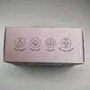 Small rectangular box with icons on a reflective surface: organic, Fair trade, ero waste and biodegradable shampoo bar. 