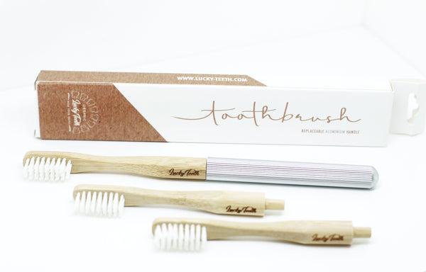Set of three bamboo toothbrushes with packaging on a white background
