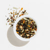 White bowl filled with a mix of dried herbs and spices on a light background