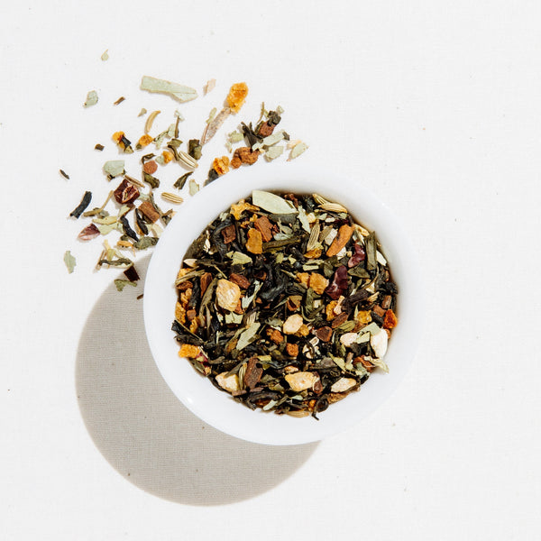 White bowl filled with a mix of dried herbs and spices on a light background