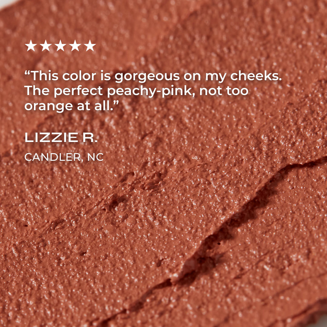 Close-up of a peachy-pink makeup product with a customer review on a white background