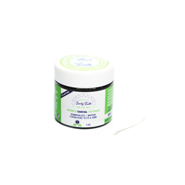 Jar of toothpaste with green and white label on a white background