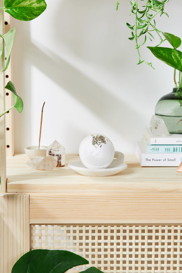 Wooden shelf with decorative items and plants on a white wall