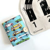 Children's book with car illustrations and a fabric bag with road and number design on a white background
