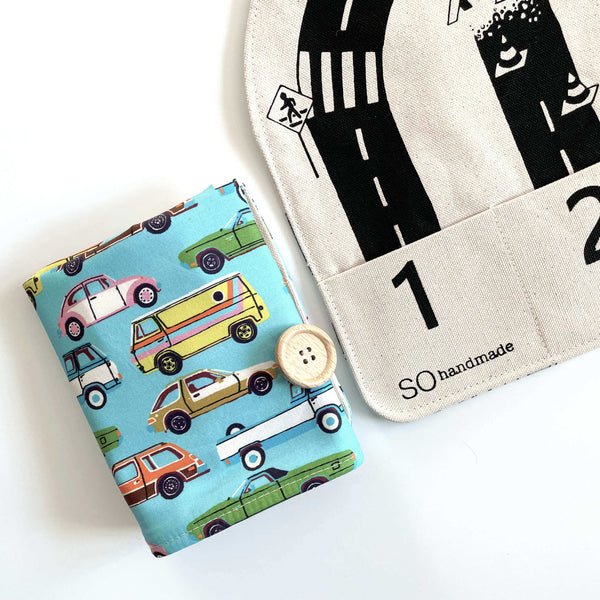 Children's book with car illustrations and a fabric bag with road and number design on a white background