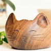 Wooden cat-shaped planter with a blurred background
