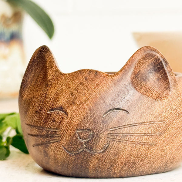 Wooden cat-shaped planter with a blurred background