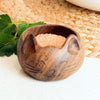 Wooden cat-shaped bowl with sand on a textured surface. Hand-carved cat salt bowl made from reclaimed wood by artisan families near Lake Atitlán, Guatemala. Holds 4 tbsp of salt or spices. Sustainable, unique, and perfect for cat lovers. A beautiful gift or kitchen essential.
