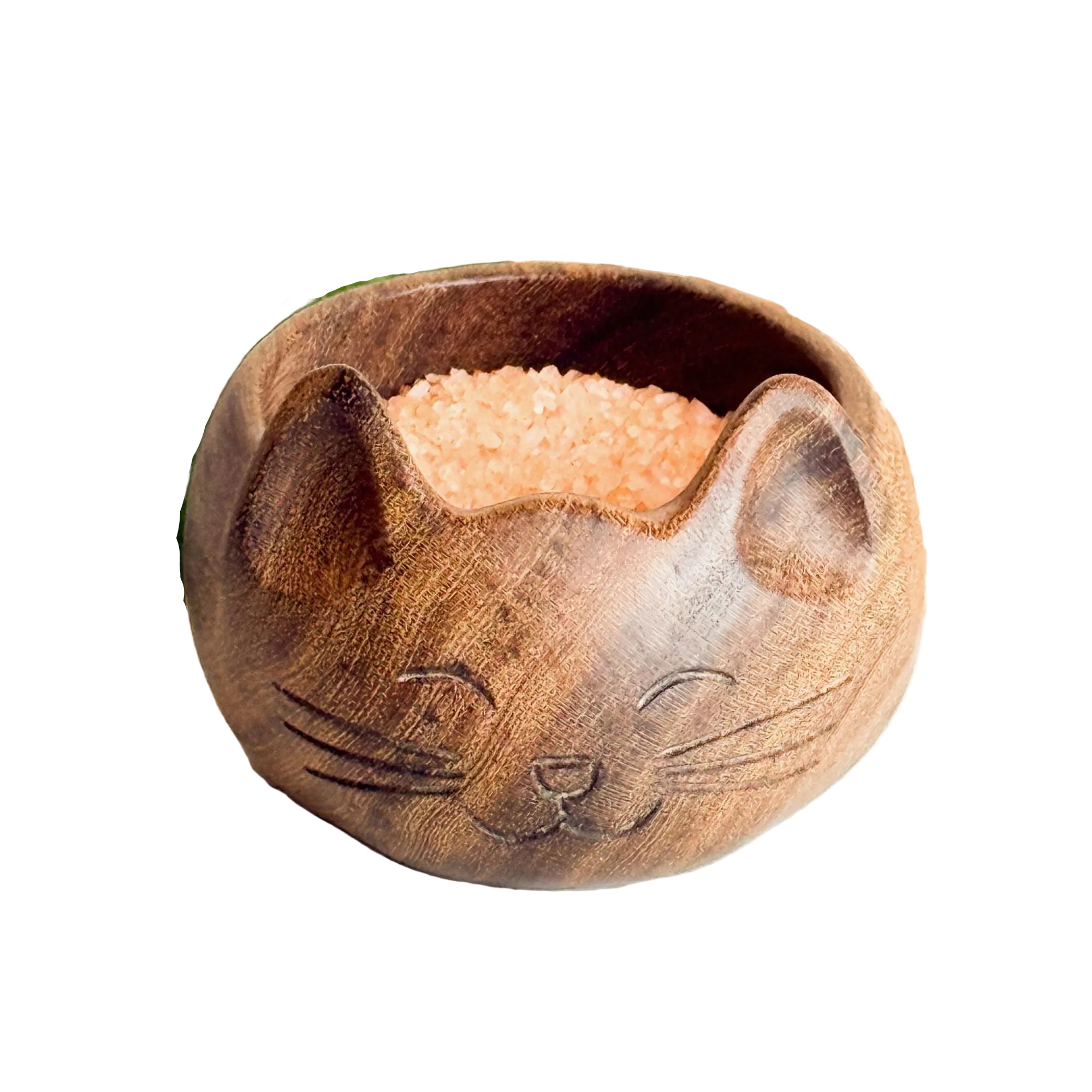 Wooden cat-shaped bowl with sand on a textured surface