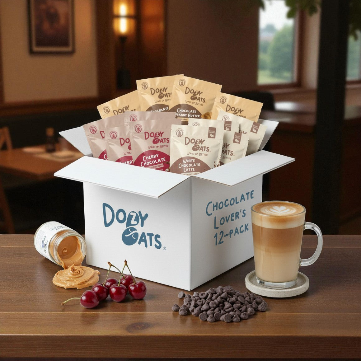 Box of Dory Oats Chocolate Lovers' 12-pack with a cup of coffee and snacks on a table.