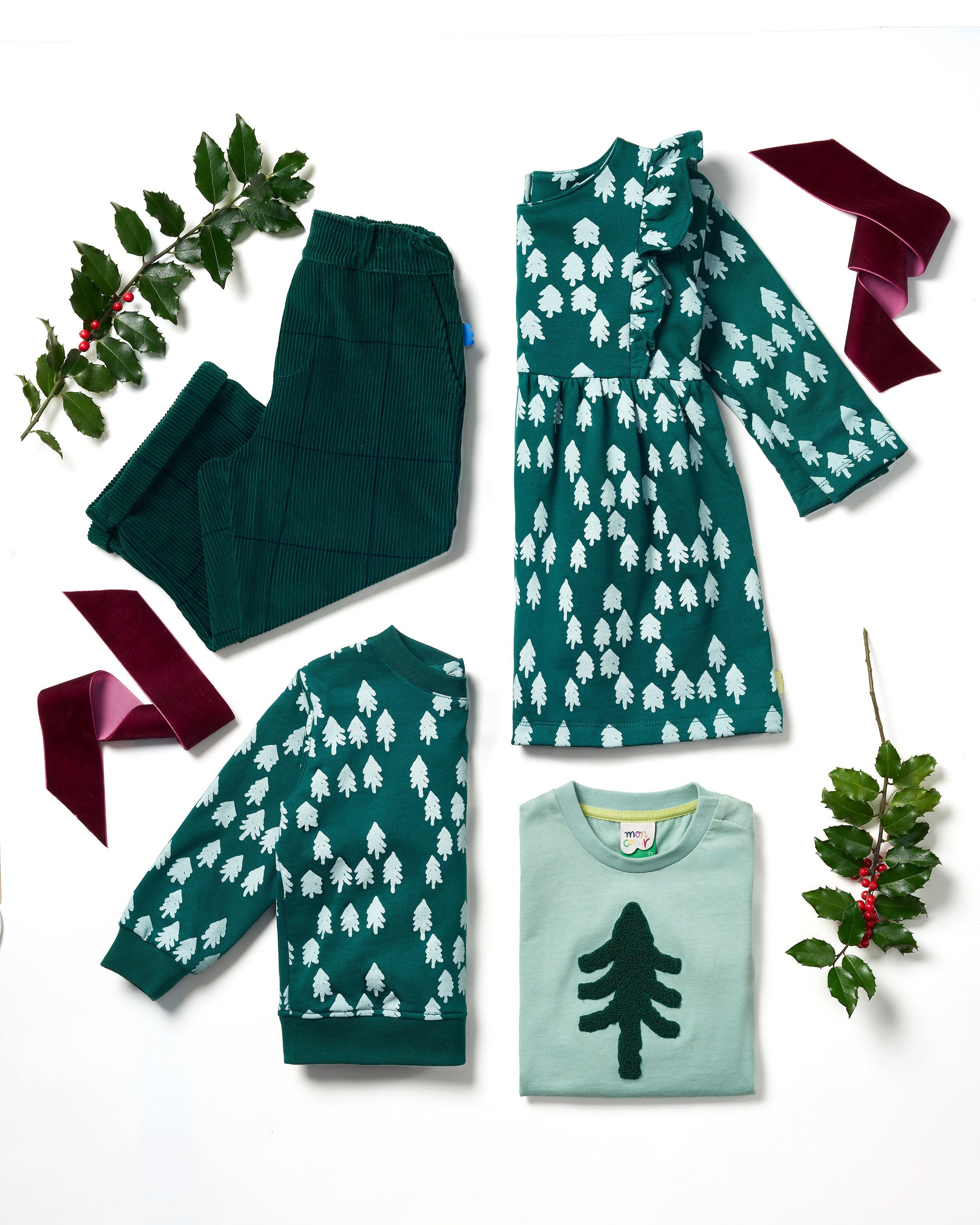 Group of children wearing matching Mon Coeur Snowy Pine T-shirts and joggers in a festive outdoor setting