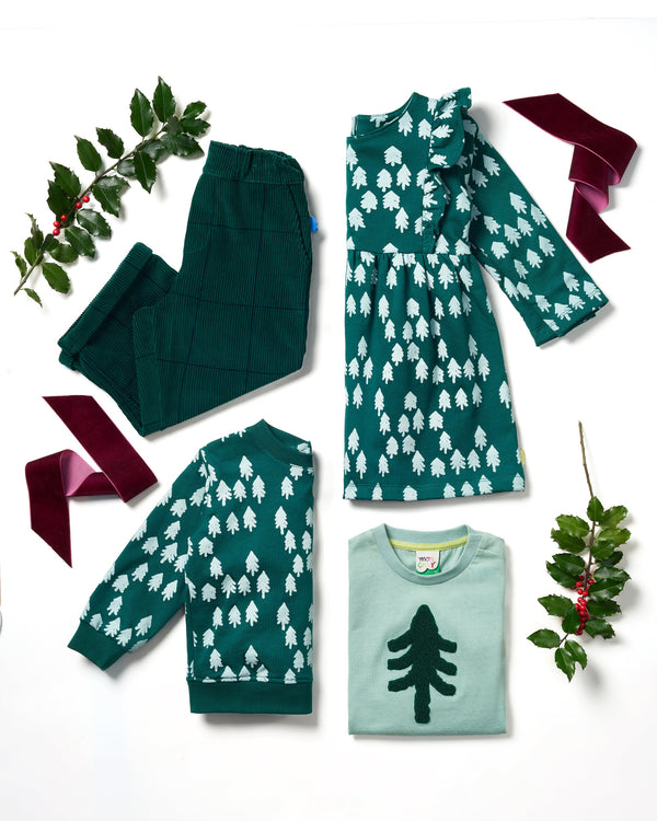 Group of children wearing matching Mon Coeur Snowy Pine T-shirts and joggers in a festive outdoor setting