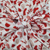Close-up of fabric with red and white pattern, including bows and candy canes.