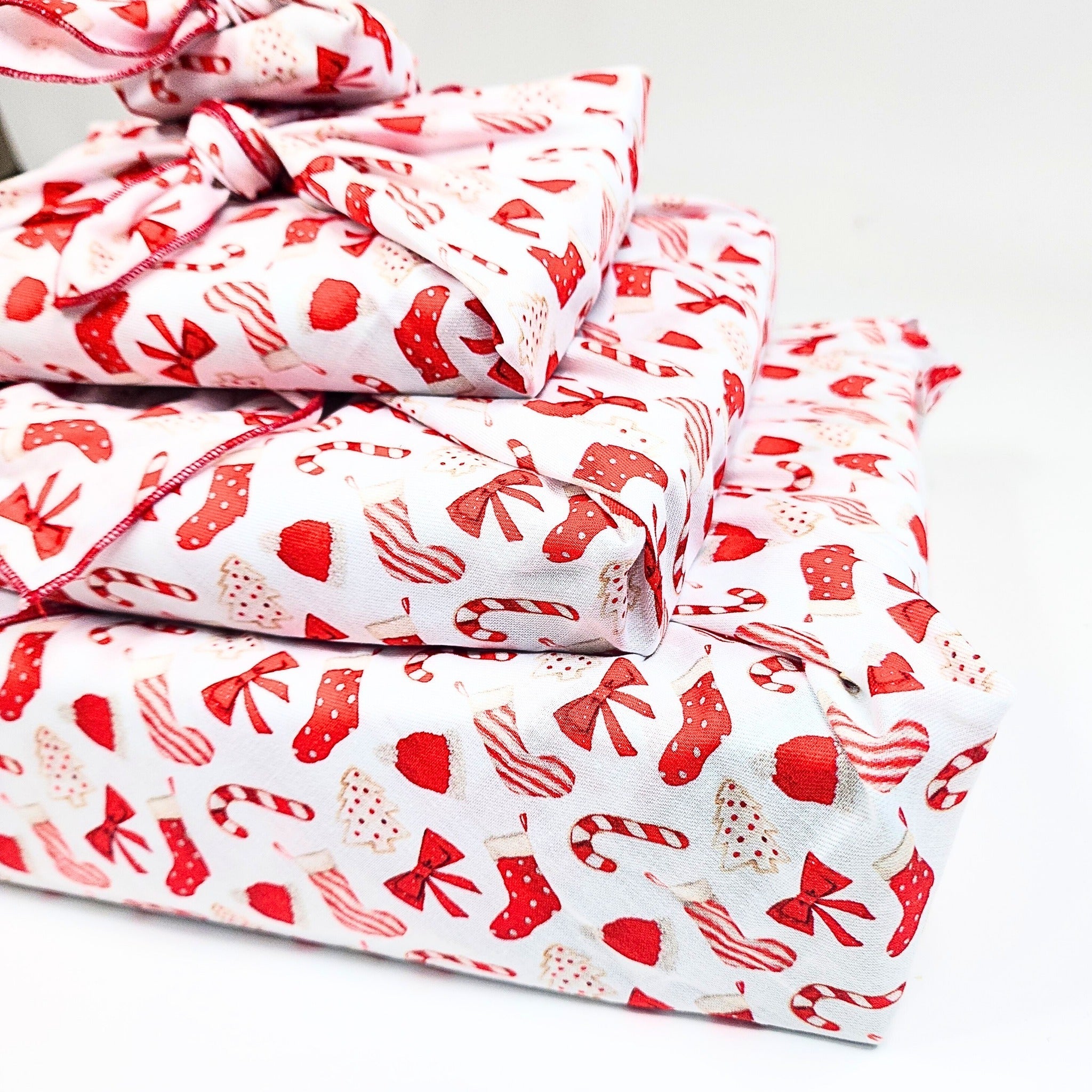 Stack of red and white patterned fabric on a white background