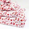Stack of red and white patterned fabric on a white background