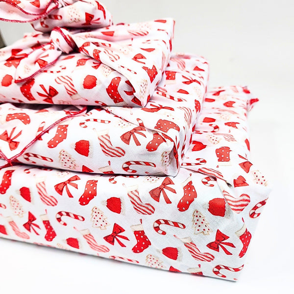 Stack of red and white patterned fabric on a white background