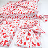Red and white patterned fabric with bows on a white background