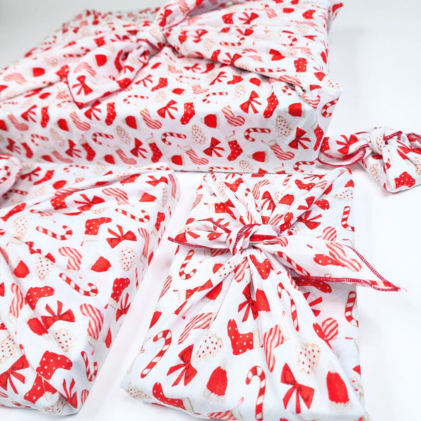 Red and white patterned fabric with bows on a white background