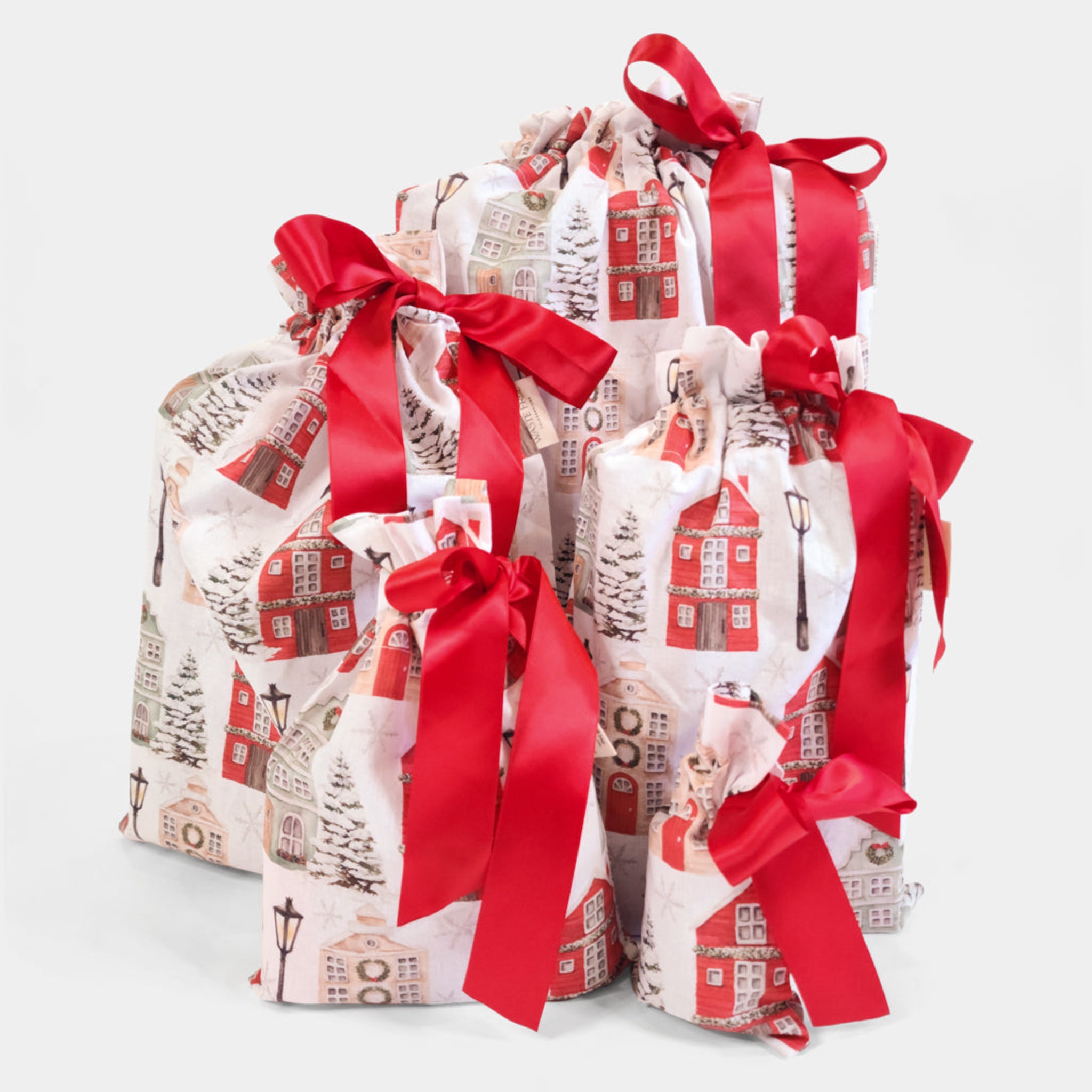 Three gift bags with red ribbons on a white background