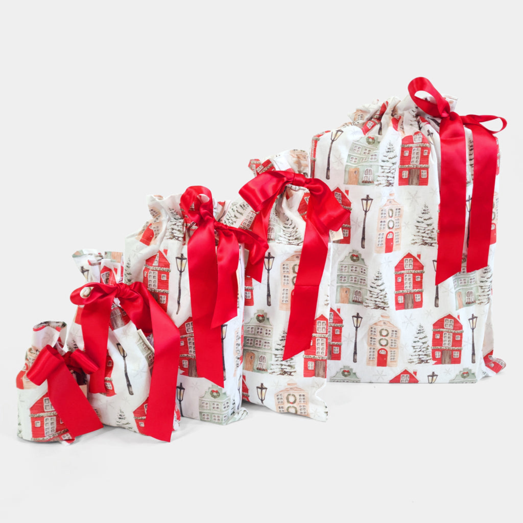 Set of gift bags with house pattern and red ribbons on a white background