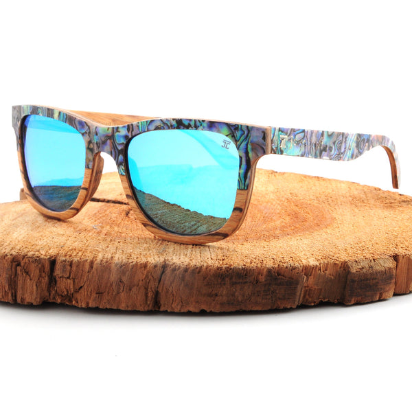 Sunglasses with blue reflective lenses on a wooden surface