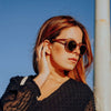 Woman wearing sunglasses against a blue sky
