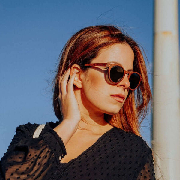 Woman wearing sunglasses against a blue sky