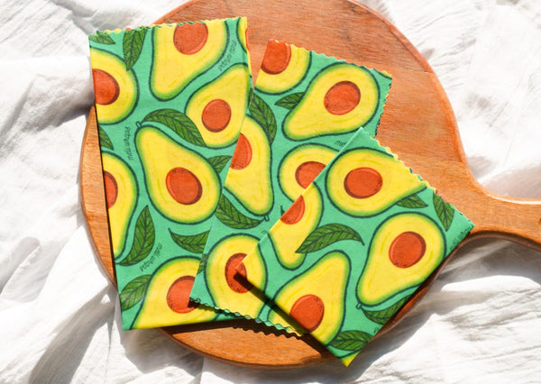 Avocado-patterned cloth on a wooden paddle with a white background