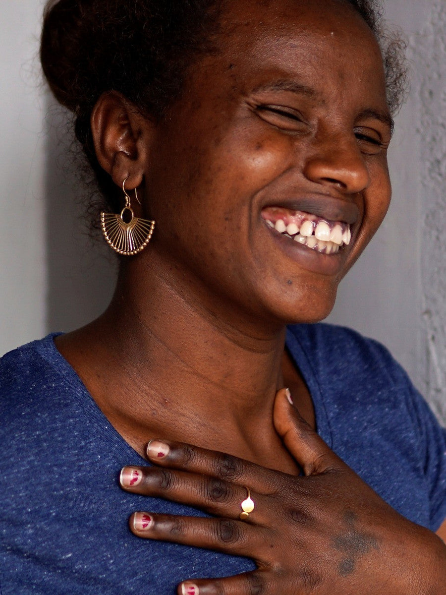 Woman wearing brass-plated palm leaf fan earrings – nickel-free fair trade earrings by Fair Anita