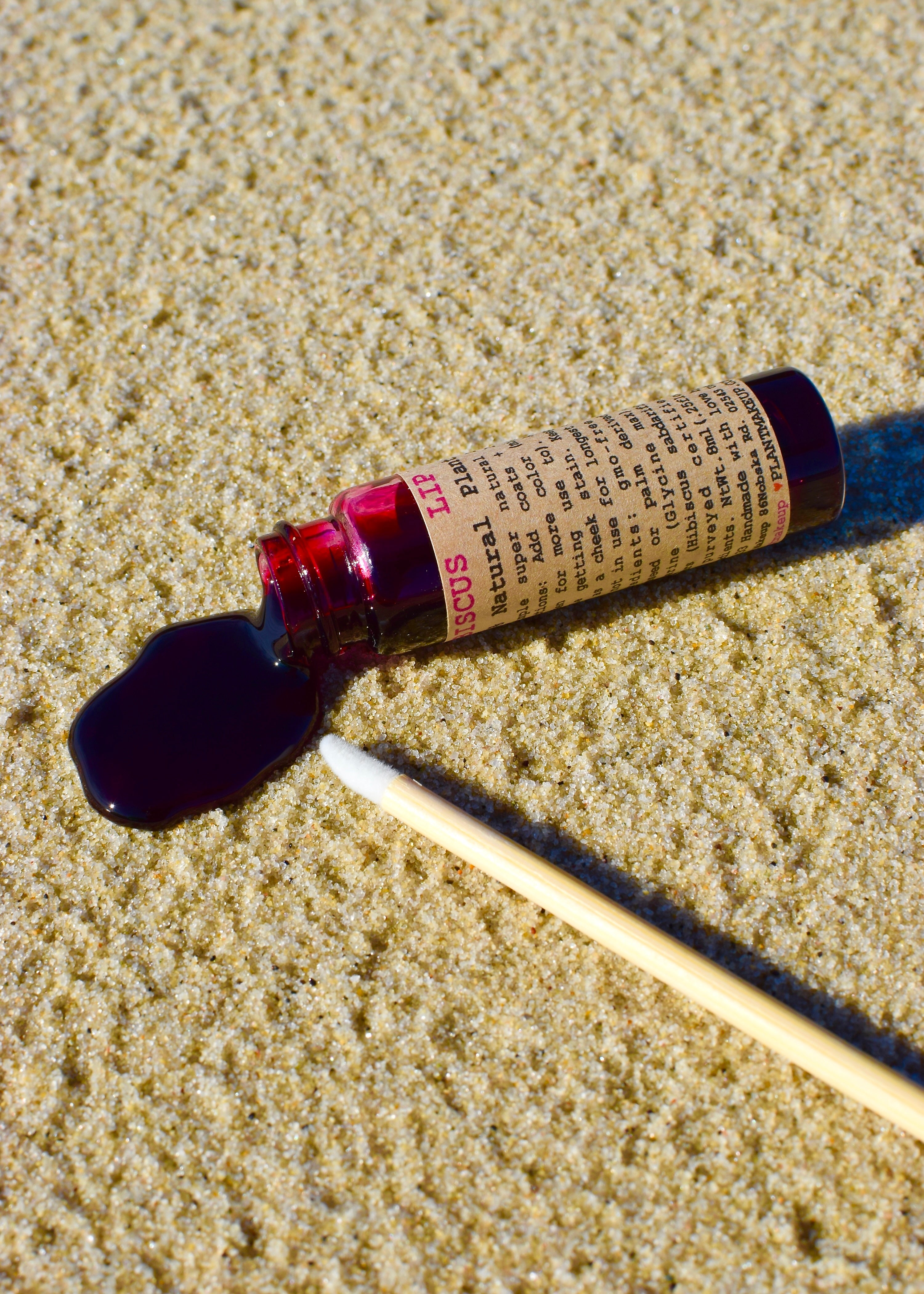 Rollerball bottle with a droplet of liquid on sand
