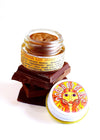 Jar of cocoa lip gloss with colorful label on a white background