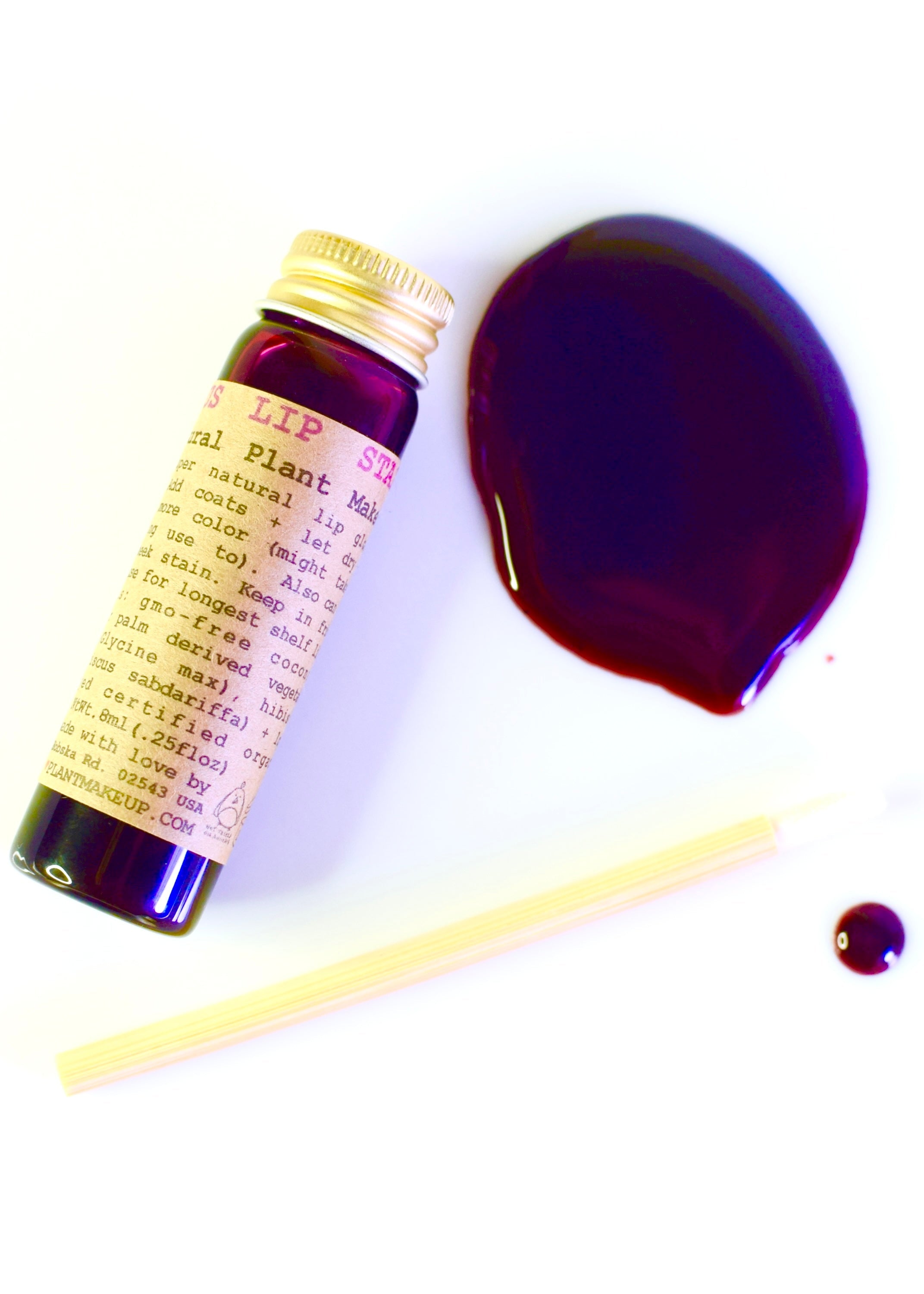 Bottle of Lush plant-based lip balm with a swatch of purple color on a white background