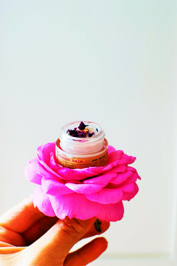 Balm with a pink flower on a white background