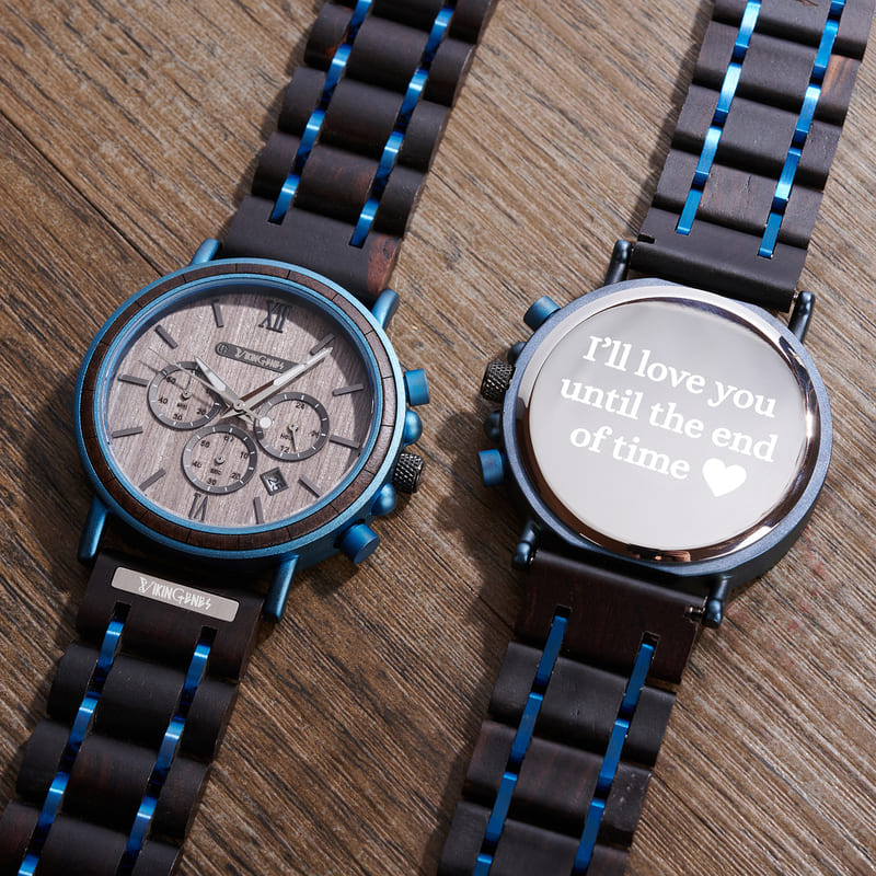 Two watches with wooden and metal straps on a wooden surface