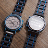 Two watches with wooden and metal straps on a wooden surface