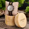 Wooden watch with engraved message in a wooden box on a rustic background