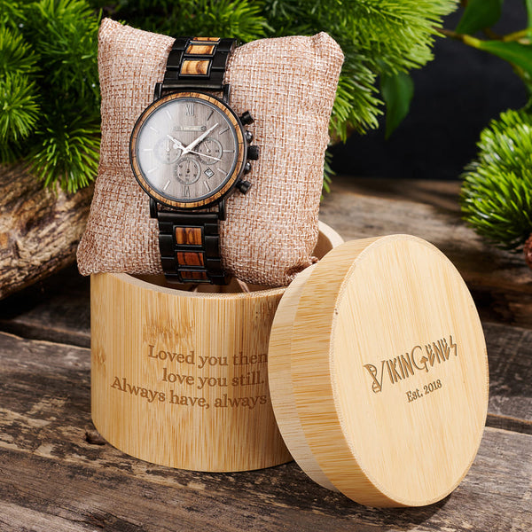 Wooden watch with engraved message in a wooden box on a rustic background