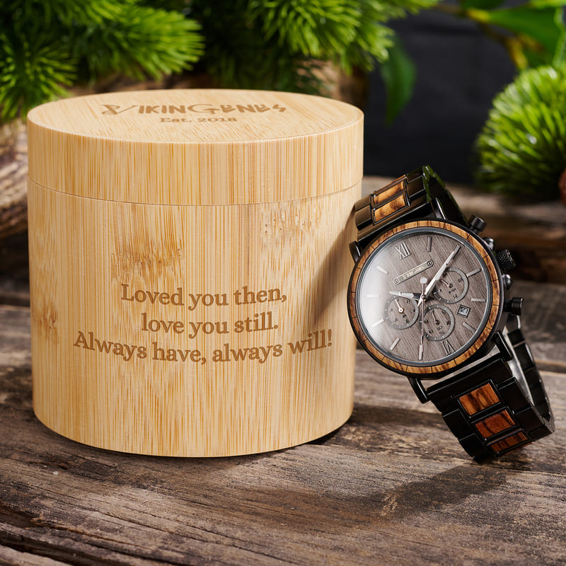 Wooden watch with engraved message on a wooden surface