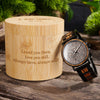 Wooden watch with engraved message on a wooden surface