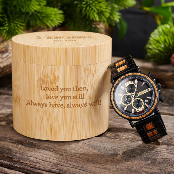 Wooden watch with engraved message in a bamboo box on a wooden surface
