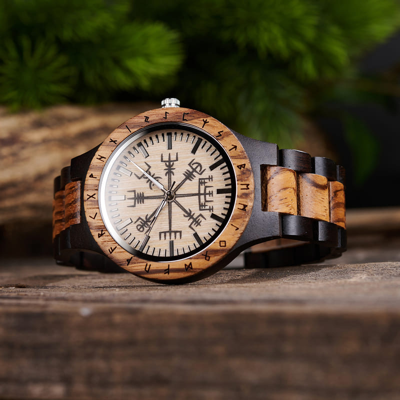 Close-up of Vegvisir runic circle engraving on handmade wooden watch face with luminous dials