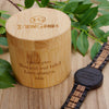 Wooden container with engraved message and a wooden watch on a wooden surface with leaves.